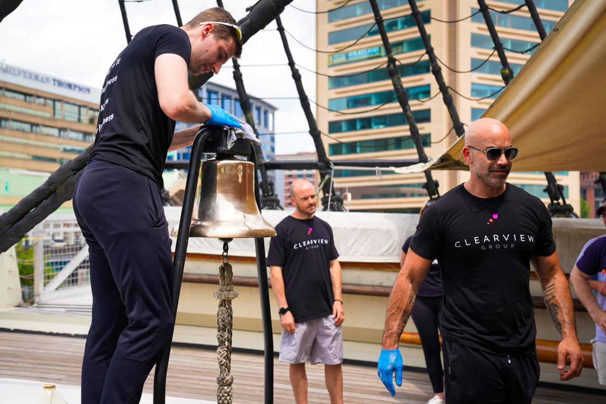 Clearview employees shine the bell aboard the USS Constellation in Baltimore's Inner Harbour.