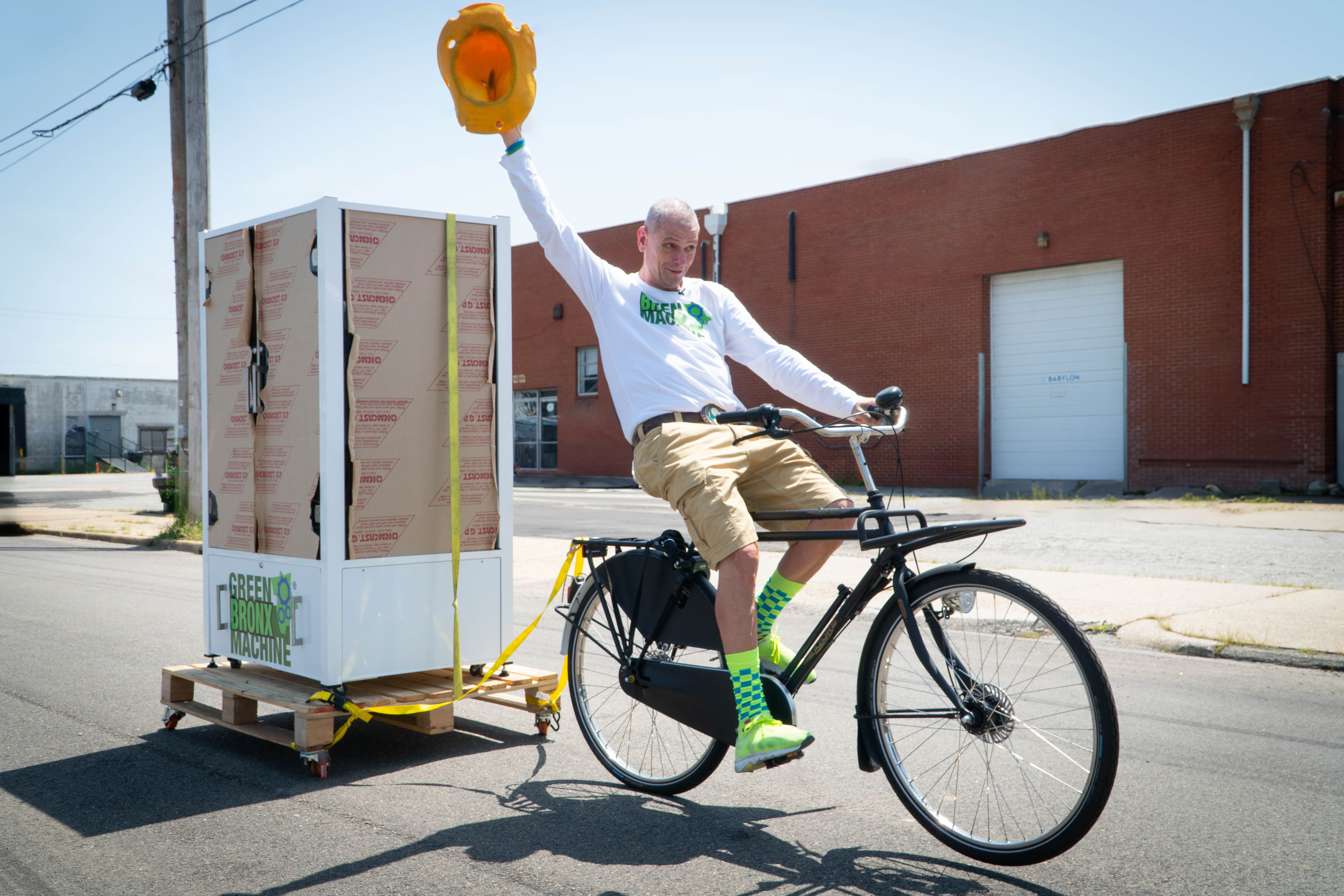 Stephen Ritz pulling a Babylon Micro-Farms STEM Garden on a bicycle